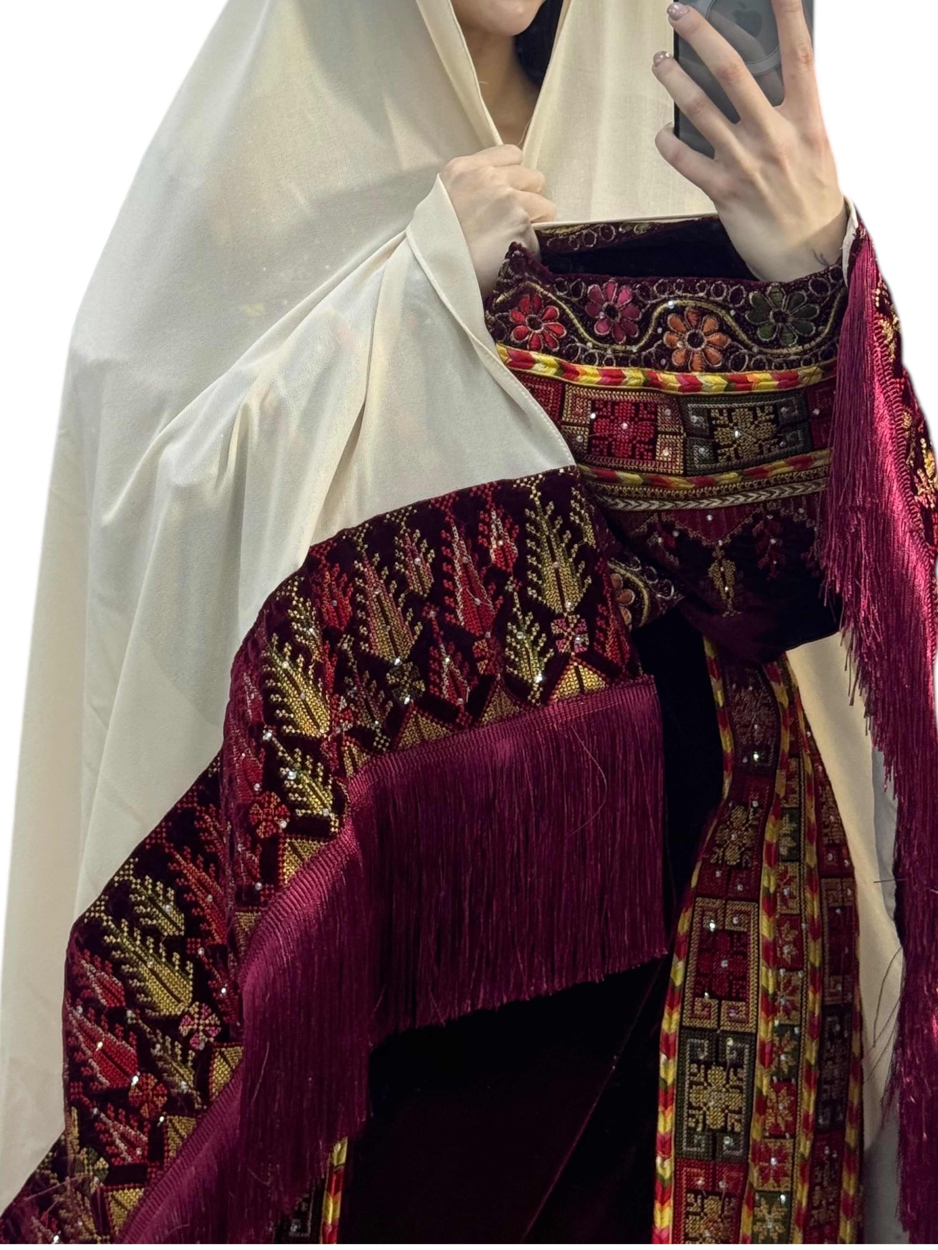 Maroon velvet Palestinian embroidered traditional long thobe with matching headpiece.