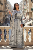 White Elegant & Bold Palestinian Thoub glow amidst city colors.